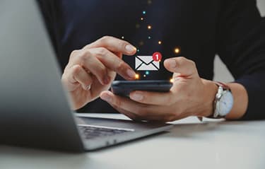 Email marketing automation concept with hand sending emails from laptop